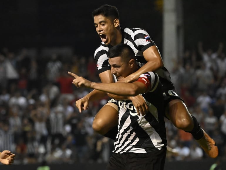 Lorenzo Melgarejo se trepa al goleador Óscar Cardozo, tras el segundo gol de Libertad frente a Luqueño.