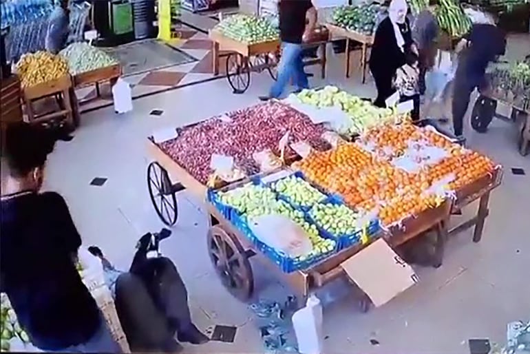 Una captura de imagen tomada de un video publicado en las redes sociales parece mostrar una explosión y un hombre cayendo al suelo (izq.) en un mercado de verduras en el interior de Beirut, mientras cientos de buscapersonas utilizados por miembros de Hezbolá explotaban en todo el Líbano, matando al menos a nueve personas e hiriendo a unas 2.800.