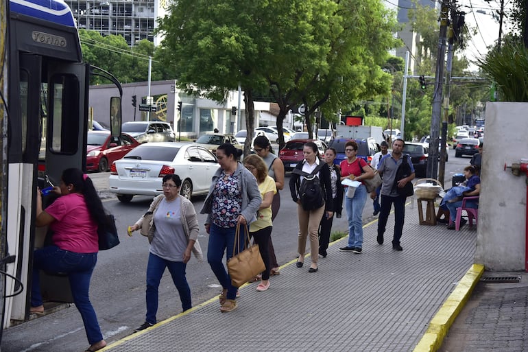 Los pasajeros forman fila para subir al bus, luego de una larga espera por las unidades. 