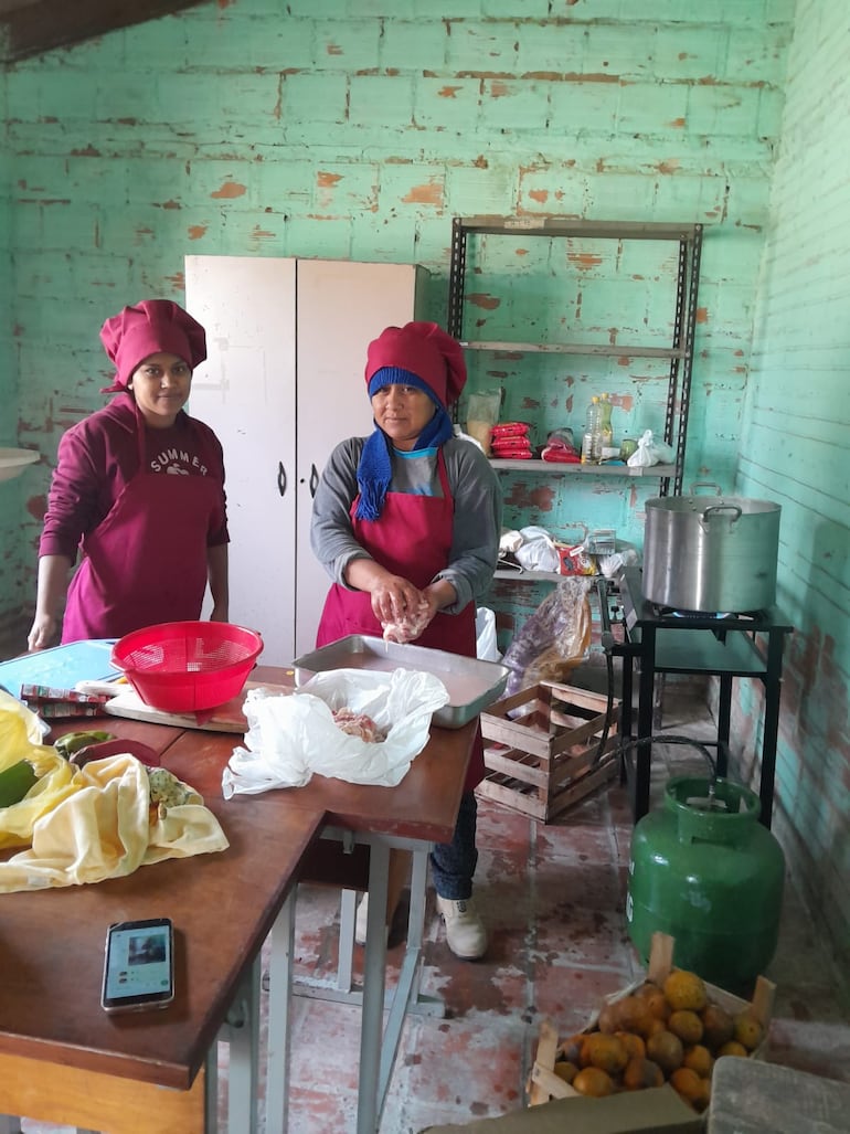 Madres de la comunidad trabajan como cocineras voluntarias para la escuela de sus hijos.