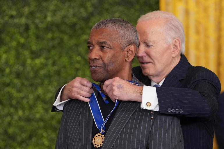 El presidente estadounidense Joe Biden condecora al actor Denzel Washington.