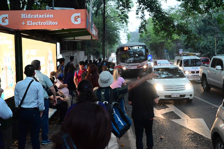 Parada del transporte público repleta de pasajeros en la avenida Mariscal López.