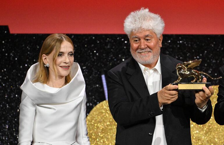 La actriz francesa Isabelle Huppert, presidenta del Jurado del Festival de Venecia, junto a Pedro Almodóvar tras entregarle el León de Oro.