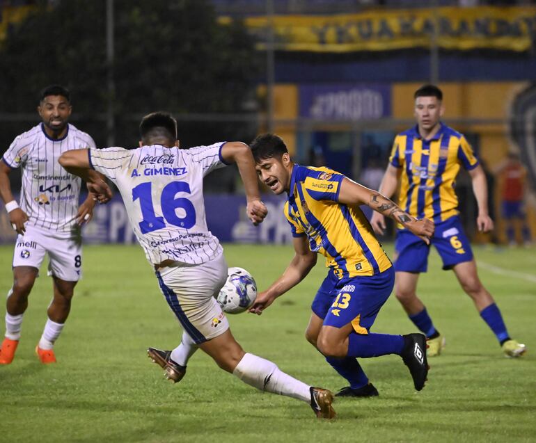 Iván Torres intenta llegar antes que el defensor de Sol de América, Aquilino Giménez, despeje el balón.