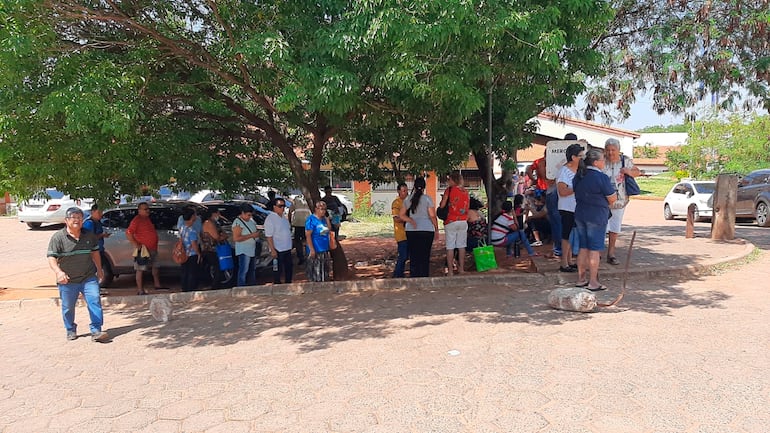 Pacientes del Hospital de Clínicas se ubican bajo los árboles mientras esperan en la fila para sacar turno para oftalmología.