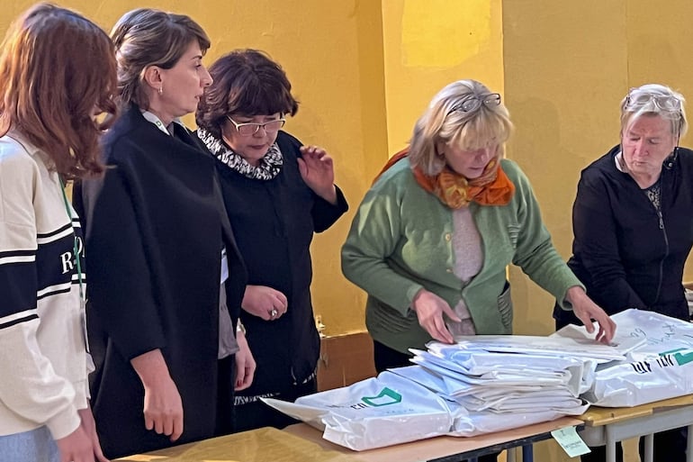 Varias personas durante el recuento de votos de las elecciones parlamentarias del pasado sábado en Georgia. La Comisión Electoral Central (CEC) de Georgia anunció hoy que efectuará un recuento de los sufragios emitidos en las elecciones parlamentarias del pasado sábado en cinco colegios de cada una de las 73 circunscripciones electorales del país. EFE/ Misha Vignanski