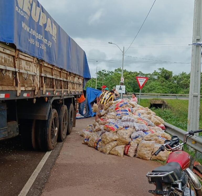 Vecinos ayudaron a cargar los fideos esparcidos sobre la calzada en otro camión de gran porte