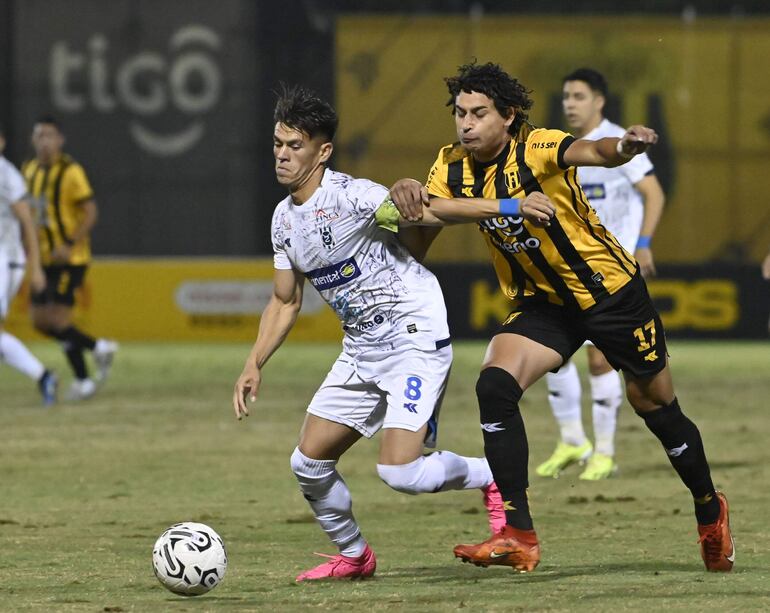 El volante del 2 de Mayo PJC, Javier Domínguez, se lleva el balón ante la marca del delantero de Guaraní Adrián Alcaraz.