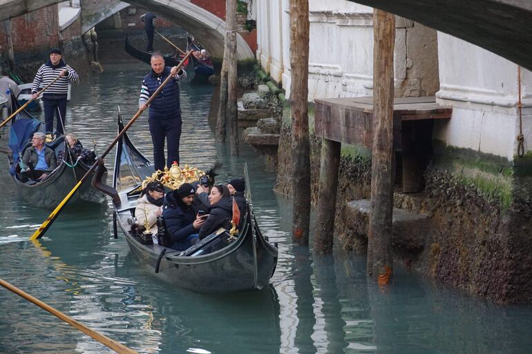 Gondoleros reman con cuidado en el río Santa María Formosa debido a la excepcional marea baja que ha registrado 70 centímetros bajo el nivel del mar, en Venecia, Italia.