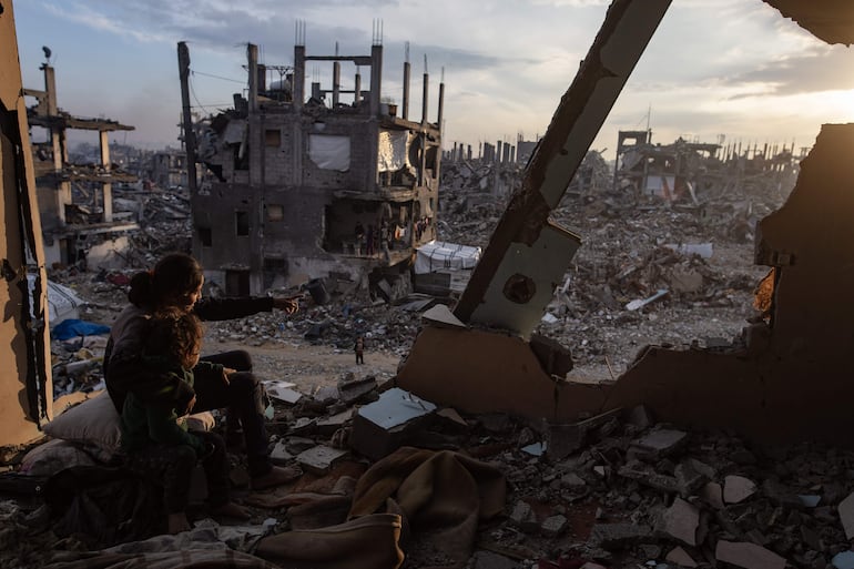 Jóvenes palestinos observan la puesta de sol desde su casa destruida en el campamento de Jabalia, al norte de la ciudad de Gaza.