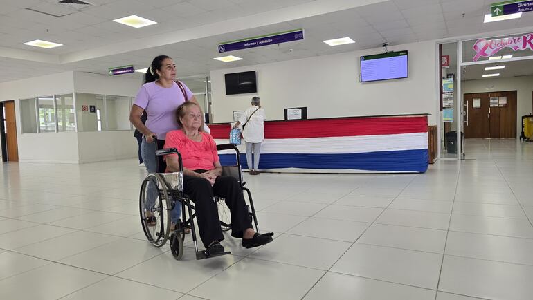 Una paciente jubilada del IPS en silla de ruedas abandona las instalaciones del seguro social luego de recibir atención médica. 