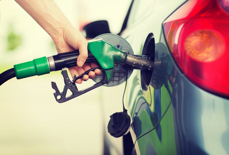 Una persona carga combustible en una estación de servicio.