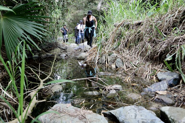 Personas caminan por un sector del río Chirapi, el 3 de agosto de 2023, 2023, en la localidad rural de Pacto (Ecuador). 