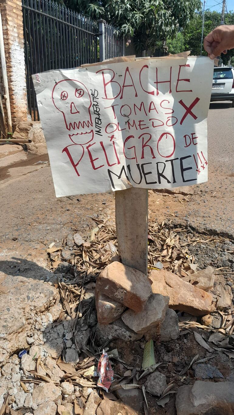 En uno de los baches los vecinos instalaron u cartel con el nombre del intendente municipal, Tomás Olmedo (ANR).