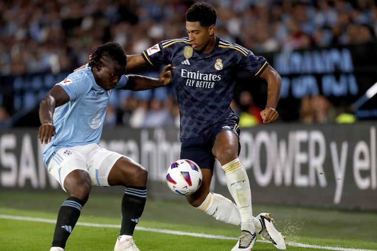 VIGO (GALICIA), 25/08/2023.- El centrocampista británico del Real Madrid Jude Bellingham (d) lucha con el ghanés Joseph Aidoo, del Celta, durante el partido correspondiente a la Jornada 3 de LaLiga que enfrenta este viernes al Celta de Vigo y Real Madrid en el estadio de Balaídos, en Vigo. EFE/Salvador Sas
