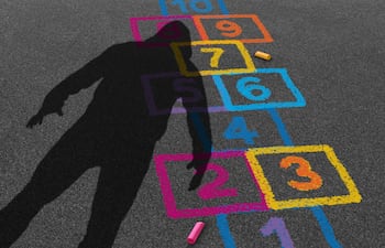 Imagen ilustrativa. La sombra de un hombre sobre un juego de "rayuela" dibujada en el asfalto en tizas de colores.