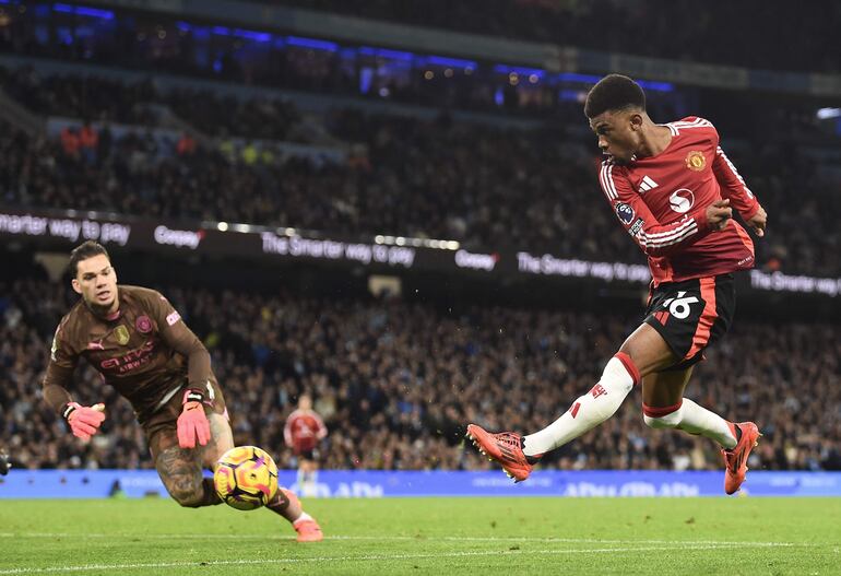 Manchester (United Kingdom), 14/12/2024.- Manchester United's Amad Diallo (R) scores the 1-2 lead against Manchester City's goalkeeper Ederson (L) during the English Premier League soccer match between Manchester City and Manchester United, in Manchester, Britain, 15 December 2024. (Reino Unido) EFE/EPA/PETER POWELL
