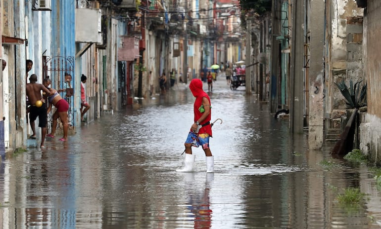 Un hombre cruza hoy una calle inundada, en La Habana (Cuba).  (EFE)