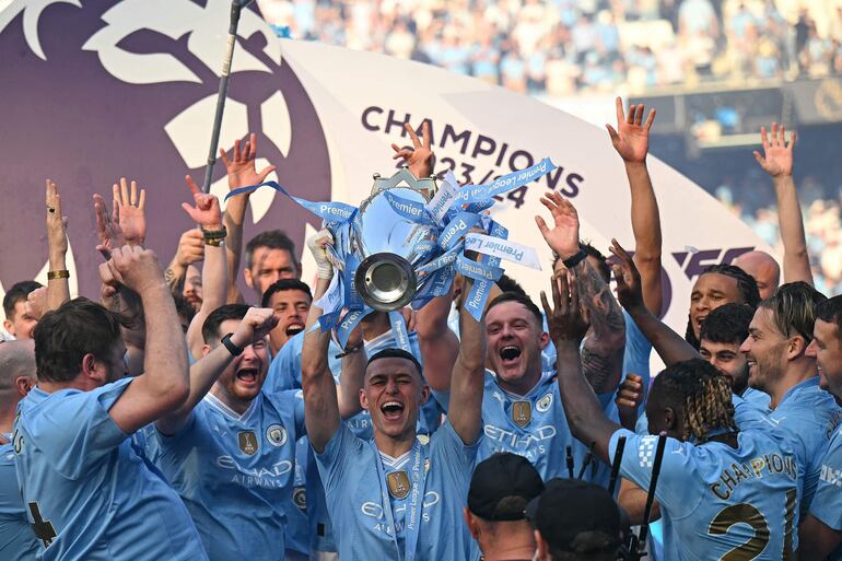 Manchester City's English midfielder #47 Phil Foden poses with the Premier League trophy after the presentation ceremony following the English Premier League football match between Manchester City and West Ham United at the Etihad Stadium in Manchester, north west England, on May 19, 2024. Manchester City created English football history on Sunday, beating West Ham 3-1 to win an unprecedented fourth straight Premier League title. (Photo by Oli SCARFF / AFP) / RESTRICTED TO EDITORIAL USE. No use with unauthorized audio, video, data, fixture lists, club/league logos or 'live' services. Online in-match use limited to 120 images. An additional 40 images may be used in extra time. No video emulation. Social media in-match use limited to 120 images. An additional 40 images may be used in extra time. No use in betting publications, games or single club/league/player publications. / 