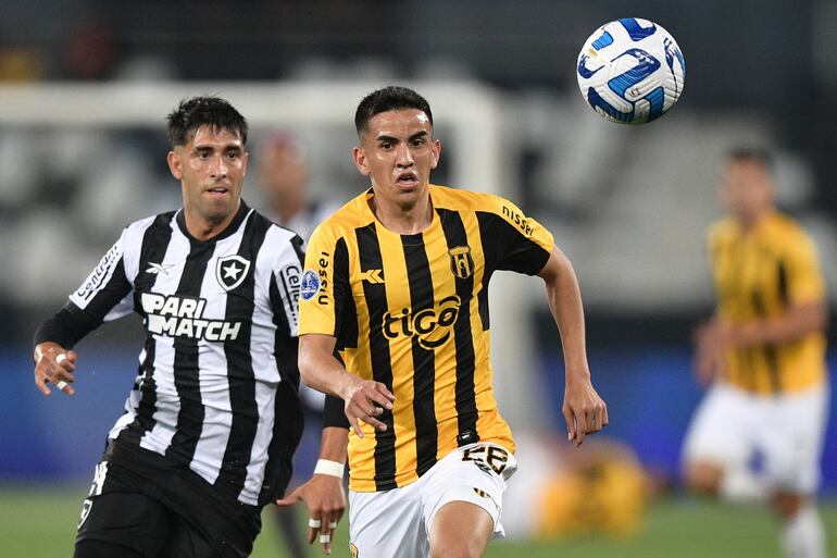 Leonel Di Placido (i), jugador de Botafogo, y Romeo Benítez, futbolista de Guaraní, pelean por el balón en el partido de los octavos de final de la Copa Sudamericana en el estadio Olímpico Nilton Santos, en Río de Janeiro, Brasil.