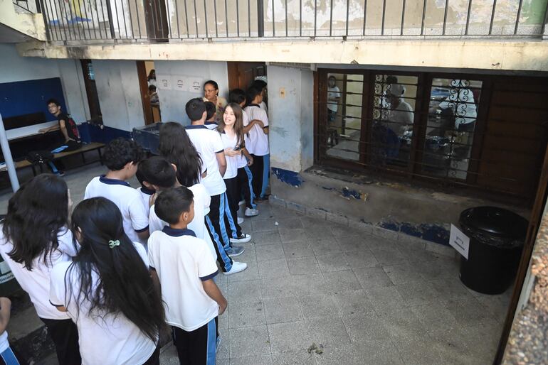 
Estudiantes forman fila para acceder al plato del almuerzo escolar y luego dirigirse al comedor.