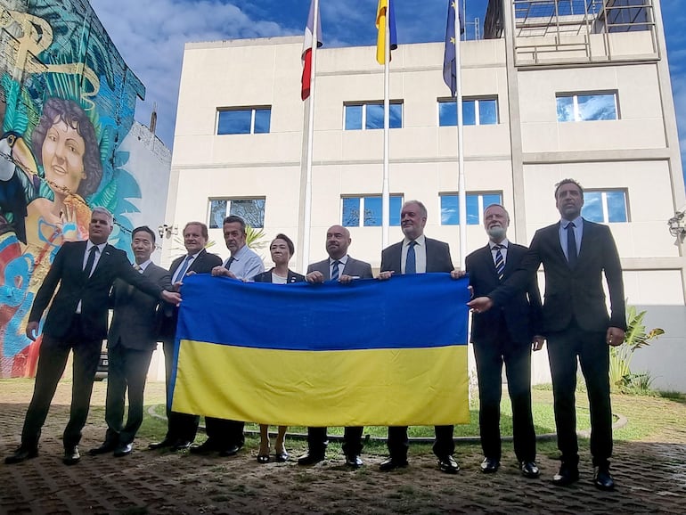 Foto de los embajadores con la bandera de Ucrania en la sede de la delegación de la Unión Europea en Asunción.