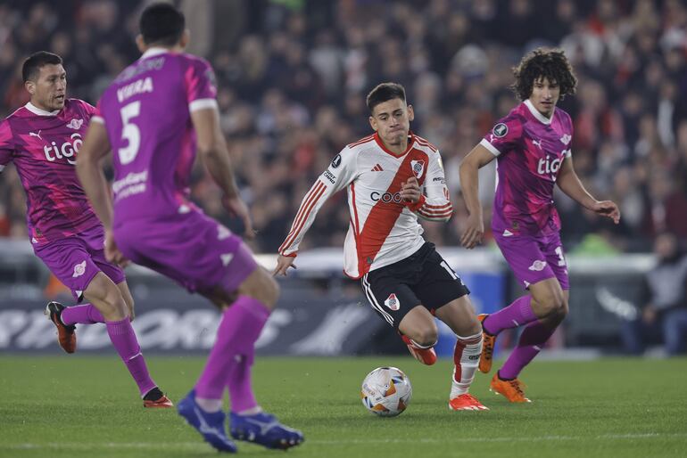 El argentino Claudio Echeverri (c), futbolista de River Plate, controla un balón ante los jugadores de Libertad en un partido de la fase de grupos de la Copa Libertadores 2024 en el estadio Monumental, en Buenos Aires, Argentina.