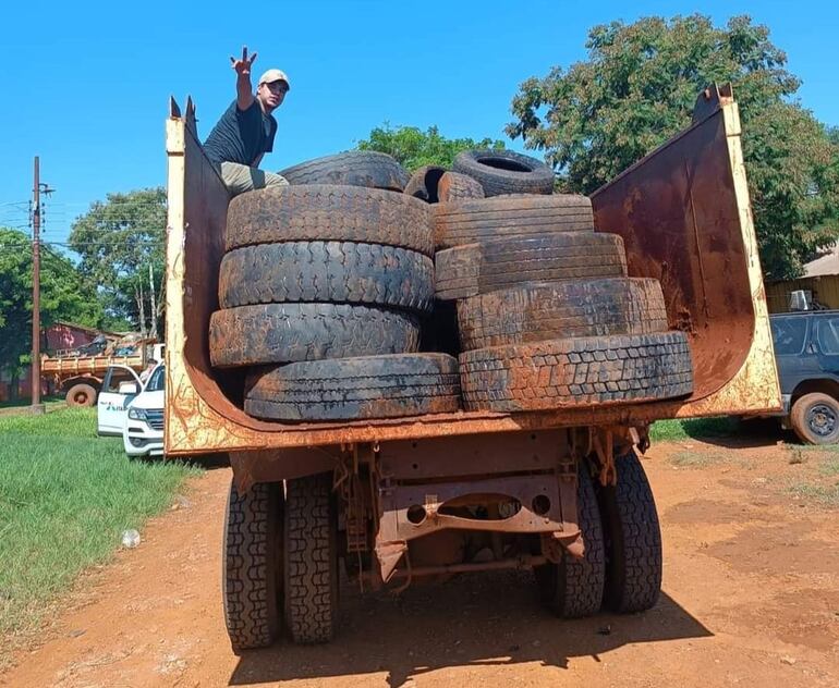 Un camión municipal traslada neumáticos en desuso. 