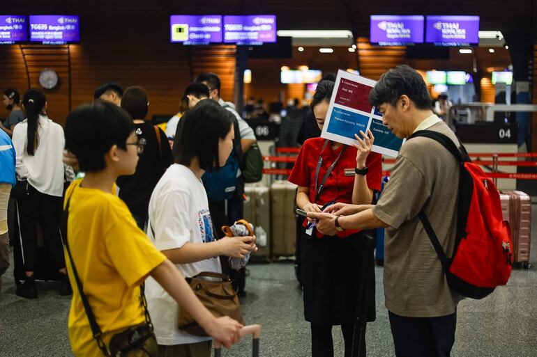 Un personal de tierra asiste a los pasajeros en el Aeropuerto Internacional de Taoyuan, en Taoyuan, Taiwán