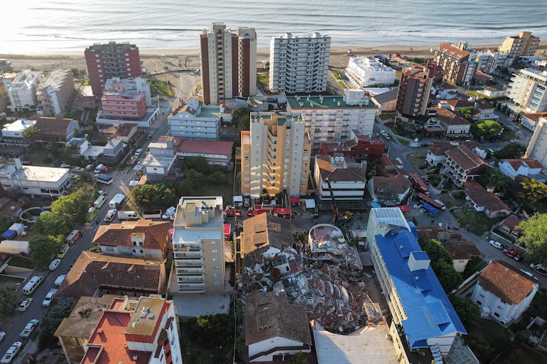 Fotografía aérea que muestra integrantes de los bomberos y grupos de rescate trabajando en la búsqueda de personas entre los escombros del edificio Aparthotel Dubrovnik este miércoles, en el municipio de Villa Gesell, provincia de Buenos Aires (Argentina). La propietaria del hotel derrumbado en la ciudad argentina de Villa Gesell, María Rosa Stefanic, de 52 años, fue hallada muerta entre los escombros, confirmaron este jueves fuentes oficiales.