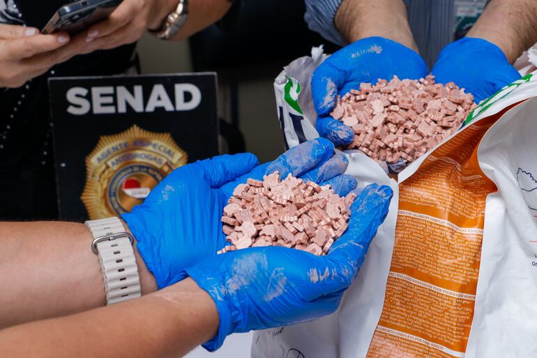 Agentes antinarcóticos muestran las pastillas de éxtasis que llegaron desde Austria, ocultas en paquetes de alimento para perros.