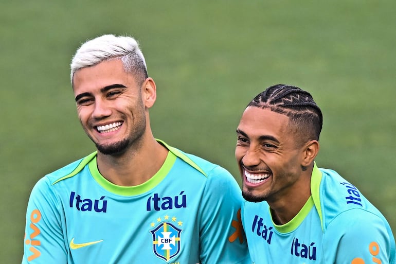 Andreas Pereira (i) y Raphinha (d), jugadores de la selección brasileña de fútbol, participa en un entrenamiento preparatorio para el partido contra Perú este sábado, en el estadio Valmir Campelo Bezerra (Bezerrão) en Brasilia (Brasil). 