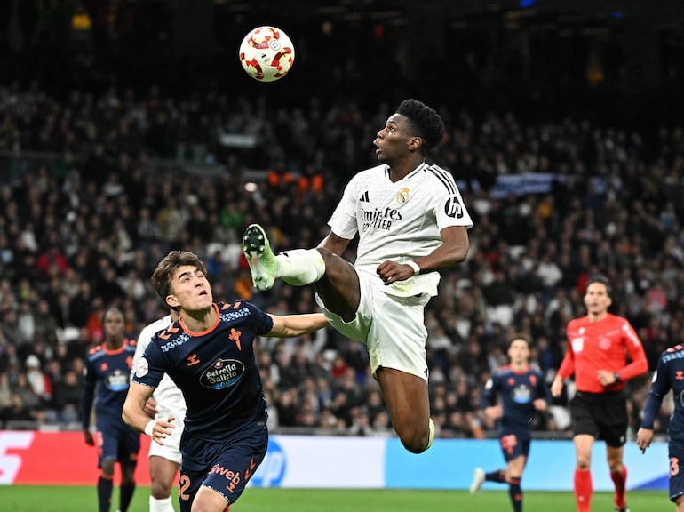 Real Madrid's French midfielder #14 Aurelien Tchouameni jumps for the ball next to Celta Vigo's Spanish defender #32 Javier Rodriguez Galiano during the Spanish Copa del Rey (King's Cup) last 16 first leg football match between Real Madrid CF and RC Celta de Vigo at the Santiago Bernabeu stadium in Madrid on January 16, 2025. (Photo by JAVIER SORIANO / AFP)