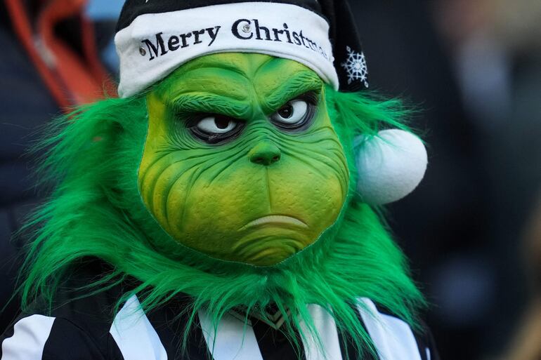 Un aficionado del Newcastle United con una máscara del Grinch asiste al partido de fútbol de la Premier League inglesa entre Newcastle United y Nottingham Forest en St James' Park en Newcastle-upon-Tyne, noreste de Inglaterra, el 26 de diciembre de 2023.
