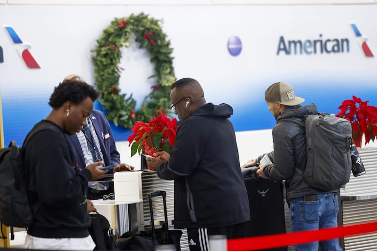 Un agente de boletos de American Airlines verifica a los pasajeros en el Aeropuerto Nacional Ronald Reagan de Washington en Arlington, Virginia, EE.UU., 24 de diciembre de 2024. Los vuelos de American Airlines estuvieron en tierra durante aproximadamente una hora el 24 de diciembre mañana debido a un problema técnico.