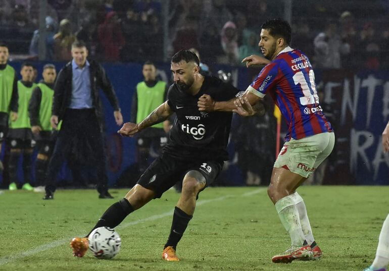 Lucas Pratto, jugador de Olimpia, y Cecilio Domínguez, futbolista de Cerro Porteño, pelean por el balón en un partido del superclásico del fútbol paraguayo en La Nueva Olla, en Asunción.