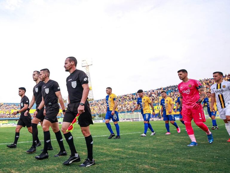 Los árbitros y los jugadores de Guaraní y Sportivo Luqueño salen al campo de juego del estadio Feliciano Cáceres para la primera fecha del torneo Clausura 2023 del fútbol paraguayo.