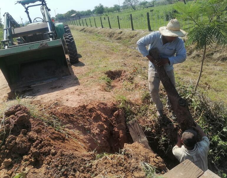 Los vecinos trabajando en la reparación de la pasarela de madera de la compañía Costa Pucú