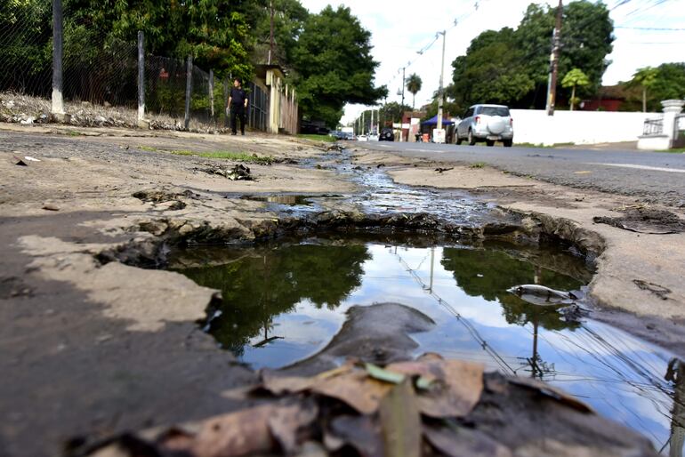 Del pozo repleto de agua servida, en una vereda de Lambaré, sobresalen varillas. Esto convierte al sitio en una trampa para los peatones.