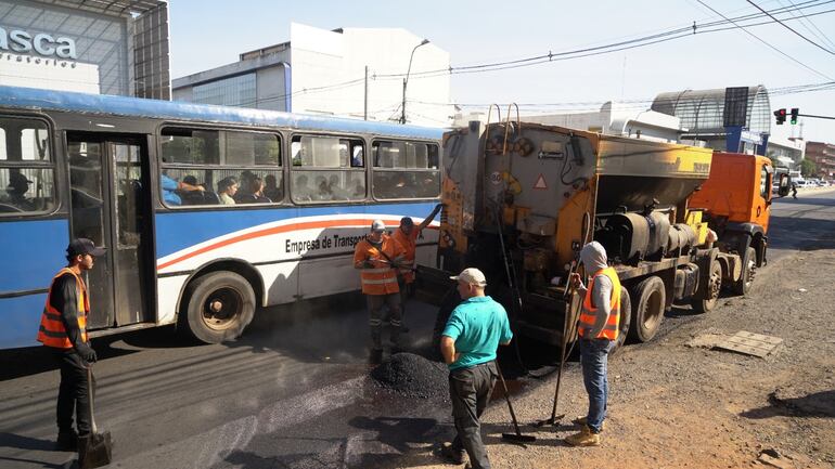 Obreros preparan el carril que será habilitado como de circulación única para los buses.