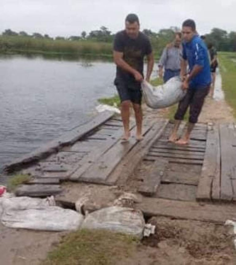 Los vecino tratan de salvar el puente para asegurar la llegada a la comunidad.