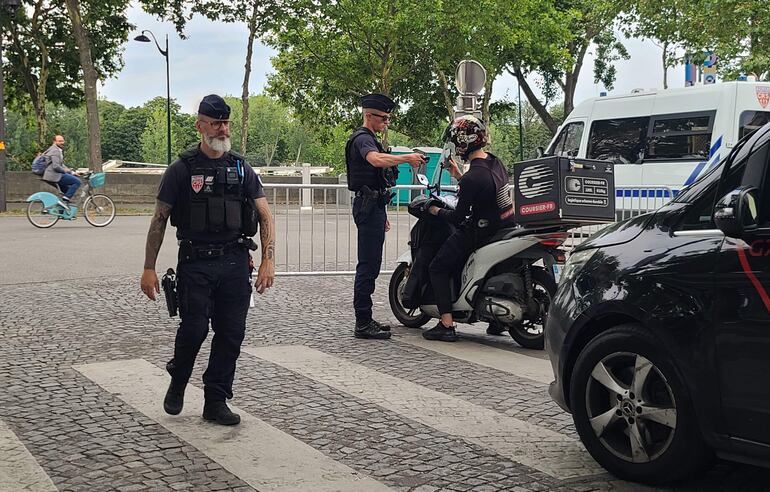 Policías paran el tráfico y a peatones en las inmediaciones del río Sena en París (Francia), durante el primer día de implementación del dispositivo de seguridad Pass Jeux, que limita la circulación en zonas emblemáticas de la capital gala, con motivo de la celebración de los Juegos Olímpicos y Paralímpicos de París 2024.