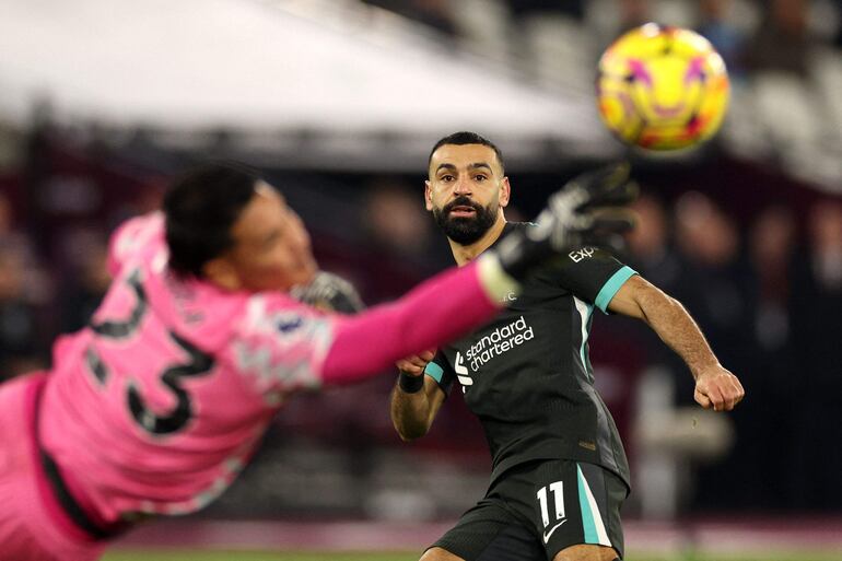 Liverpool's Egyptian striker #11 Mohamed Salah looks on as West Ham United's French goalkeeper #23 Alphonse Areola saves his shot during the English Premier League football match between West Ham United and Liverpool at the London Stadium, in London on December 29, 2024. (Photo by Adrian Dennis / AFP) / RESTRICTED TO EDITORIAL USE. No use with unauthorized audio, video, data, fixture lists, club/league logos or 'live' services. Online in-match use limited to 120 images. An additional 40 images may be used in extra time. No video emulation. Social media in-match use limited to 120 images. An additional 40 images may be used in extra time. No use in betting publications, games or single club/league/player publications. / 