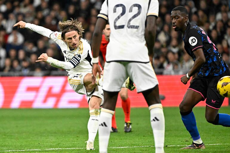 Real Madrid's Croatian midfielder #10 Luka Modric scores his team first goal during the Spanish league football match between Real Madrid CF and Sevilla FC at the Santiago Bernabeu stadium in Madrid on February 25, 2024. (Photo by JAVIER SORIANO / AFP)