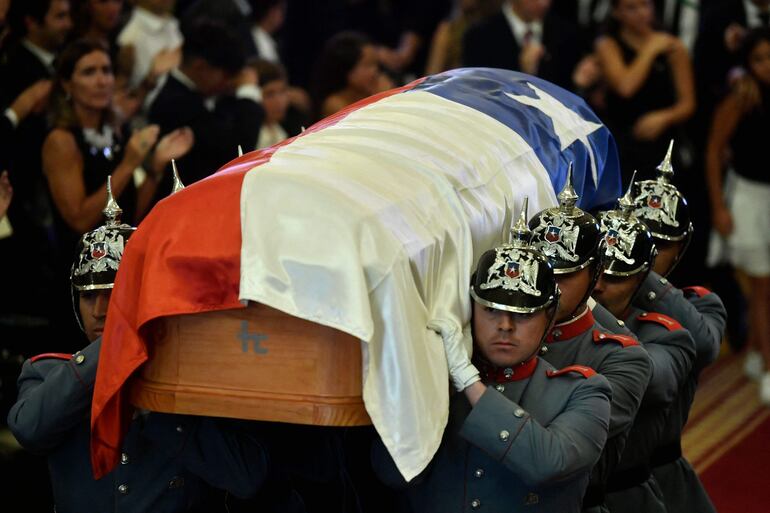 Carabineros de Chile cargan el féretro del expresidente Sebastian Piñera. 