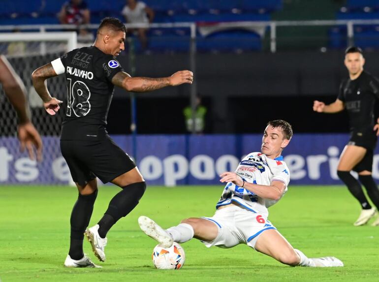 Paulinho (Corinthians) pelea el balón con Juan Alfaro (Nacional).