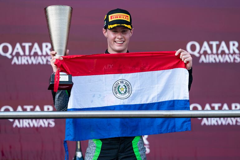 El piloto Joshua Duerksen celebra con la bandera paraguaya el triunfo en la carrera sprint de la Fórmula 2 en Azerbaiyán.