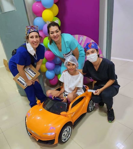 Uno de los pequeños pacientes junto a las profesionales de salud post cirugía.