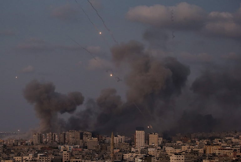 Militantes de la milicia Ezz Al-Din Al Qassam, brazo militar del movimiento Hamás, lanzan cohetes desde la costa de la Franja de Gaza hacia Israel, en la ciudad de Gaza, ayer 12 de octubre de 2023.