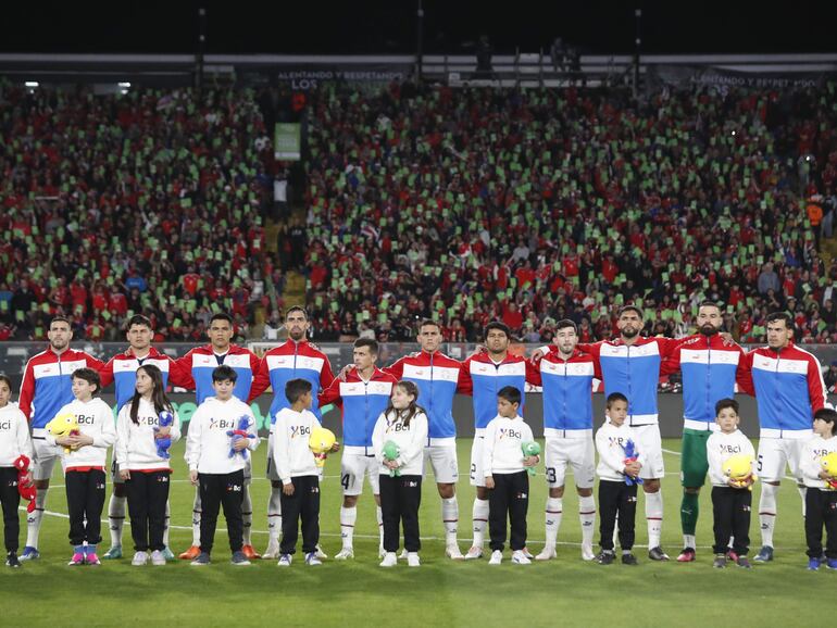 Los jugadores de la selección paraguaya forman en la previa de un partido de las Eliminatorias Sudamericanas 2026 frente a Chile en el estadio Monumental, en Santiago de Chile.